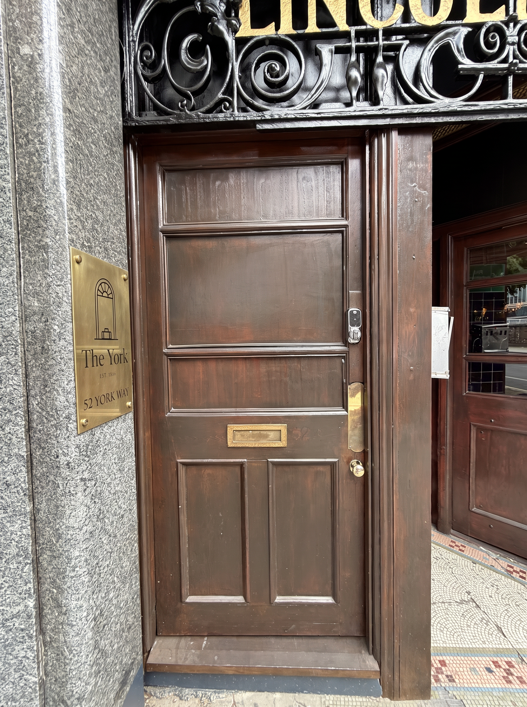 Aged brass plate on the stone pillar beside the front door