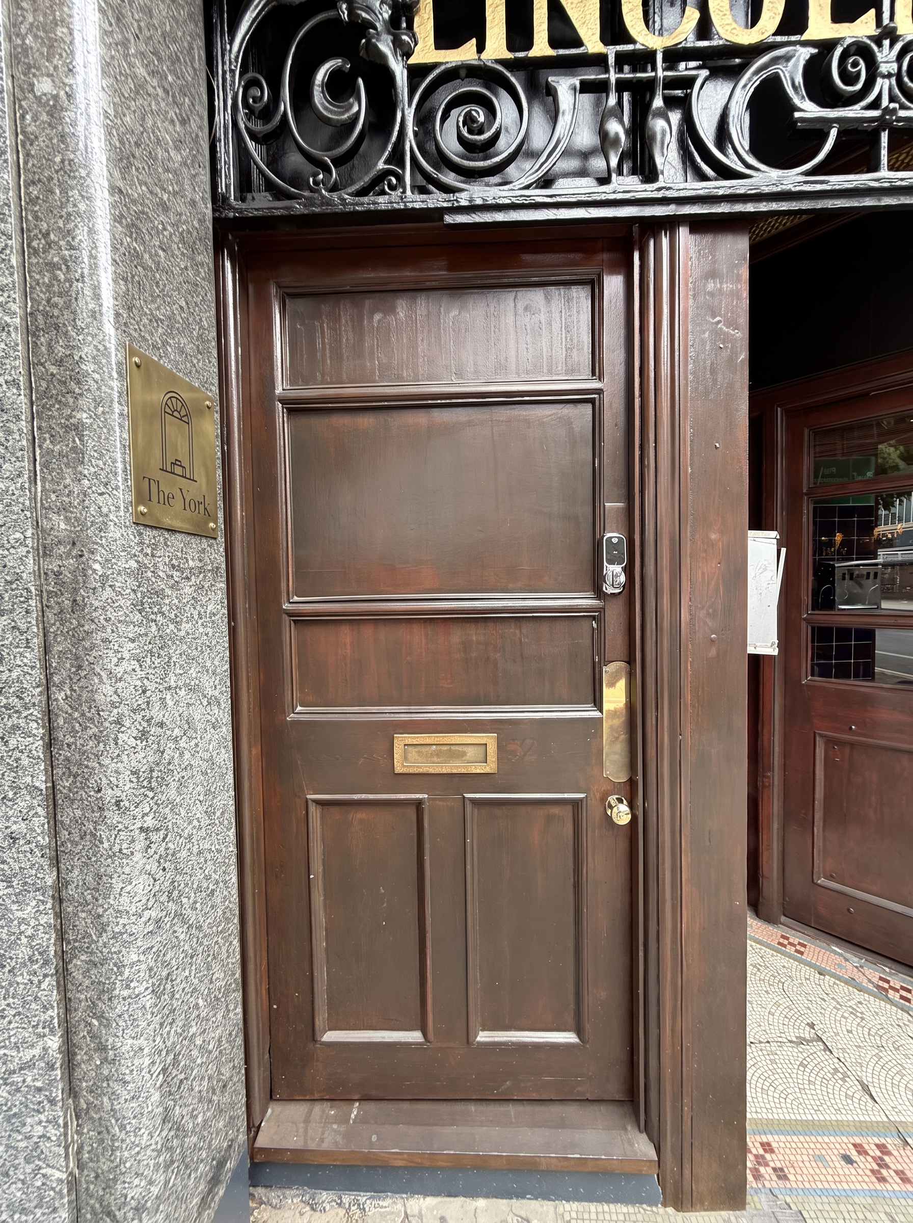 Small brass plate set high on the stone pillar