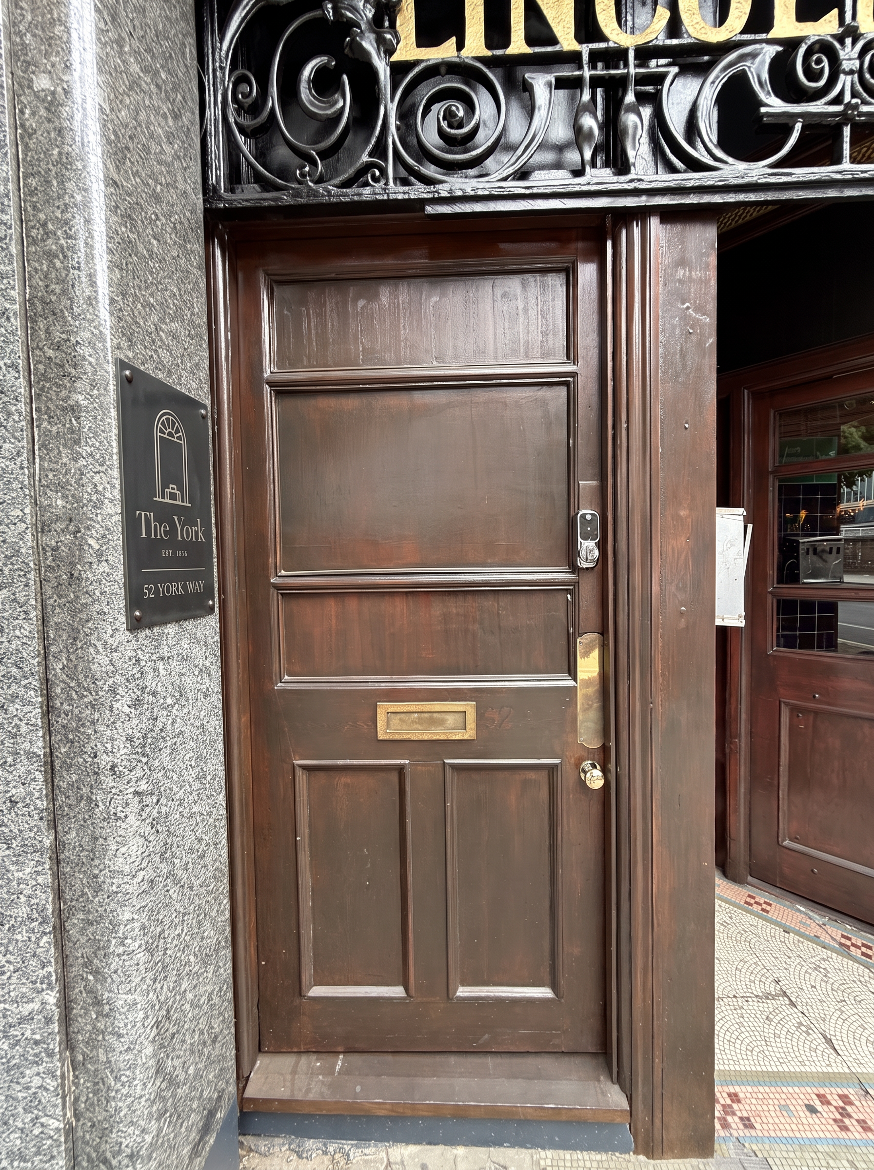 Dark bronze plate on the stone pillar beside the front door